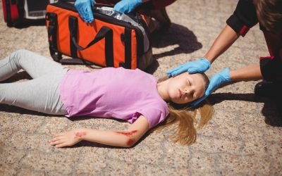 Paramedics examining injured girl on street